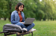 © Prostock-studio - Distant Learning. Young Arab Female Student Using Laptop While Sitting On Bench Outdoors In Park, Smiling Middle Eastern Woman Watching Educational Webinar, Enjoying Remote Study, Copy Space