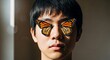 © Richafuji - Portrait of a young Asian man with digitally added butterfly wings over his eyes brown background and soft lighting creates a serene atmosphere.