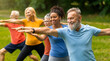 © Prostock-studio - Group of diverse seniors led by young instructor practicing warrior yoga pose outdoors, happy elderly people promoting inclusivity and wellness, exercising in lush park setting, closeup shot