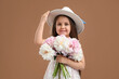 © New Africa - Cute little girl with bouquet of beautiful peonies on brown background