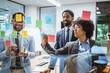 © Miljan Živković - Coworkers brainstorming and planning use sticky notes on glass wall