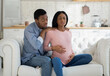 © Prostock-studio - Worried black husband supporting pregnant wife with prenatal contractions at home. Beautiful African American woman suffering from pain, giving birth to baby with help of her partner