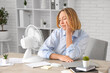 © Pixel-Shot - Beautiful mature sleepy businesswoman with electric fan suffering from heat in office