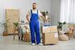 © Pixel-Shot - Delivery man with parcel boxes in room