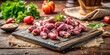 © Songkran - Fresh raw chicken hearts on a stone cutting board with a rustic wooden chopping board in the background, food preparation, food photography