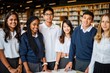 © Rawpixel.com - Group of diverse students in school uniforms smiling in a library. Students in uniforms, diverse group, library, smiling students, school uniforms. Diverse students in library, education concept.