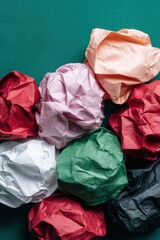 Poster - Crumpled Colored Paper Balls with Textured Wrinkles on Green Background - Abstract Creativity and Sustainable Design with Modern Material Aesthetic