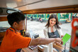 © Leo Lintang - Indonesian southeast asian male with a Chinese female couple barista holding a tablet while discussing in their coffee shop. Mockup or copy space. A small business of a coffee shop or cafe on a truck