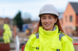 © Iryna - Portrait of Young female Construction works superviser overseeing building site activities  during sunny day while holding project files and wearing safety gear