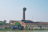 Vegetation sprouts from the chimney of an abandoned jute mill on the banks of the Hooghly river  in Calcutta, India