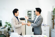 © Nuttapong punna - Professional handshake between two businessmen sealing a successful agreement in a modern office