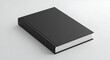 © Flatart - Black book lying flat on a light gray surface. Blank cover showcasing design possibilities. Generic book mockup for advertising or editorial use.