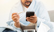 © Kunlathida - Sick man with flu holding a termometer and check  temperature with medical information