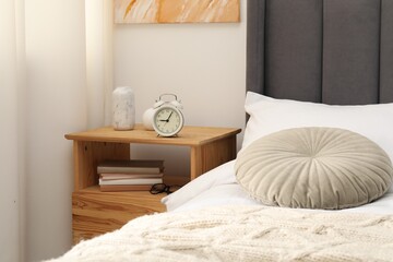 Aufkleber - Bedside table with alarm clock and decor near bed indoors