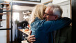 © Westend61 - Senior couple embracing happily in their kitchen at home