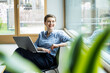 © Westend61 - Businesswoman in office with laptop smiling and looking away