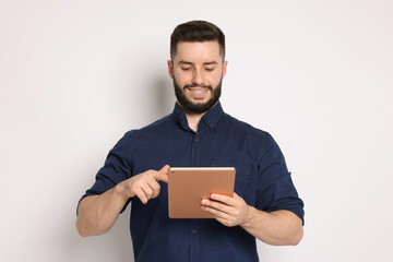 Handsome man using tablet on white background