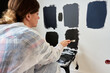 © Lazy_Bear - Woman in protective wear applies different dark paint swatches on white wall using brush. Female painter testing black and dark gray paint samples during interior renovation project in modern home