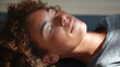 © JoeyMarut - Closeup of person with curly hair and freckles lying down with eyes closed, enjoying peaceful moment in soft natural light. skin texture and relaxed expression are visible