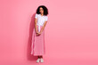 © deagreez - Young woman in pleated pink skirt and white shirt posing against a pink backdrop, showcasing casual and fashionable style
