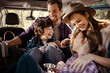 © Davor - Happy family sitting in car taking pictures during road trip