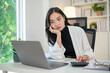 © wattana - Bored businesswoman working with laptop and calculator in modern office.