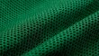 © suyu - Close up detail of green sportswear fabric showing mesh texture and breathable material structure used in modern football shirts and athletic jerseys, representing comfort, ventilation, performance