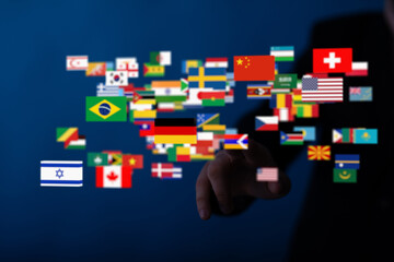 Fototapete - Image of a hand interacting with a digital display of world flags, symbolizing global connection and communication.
