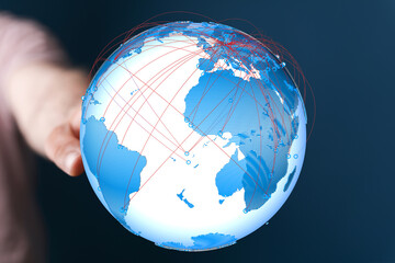 Fototapete - A hand holds a digital globe, illustrating global connections and networking.