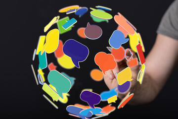 Poster - Hand interacting with a sphere of colorful speech bubbles, symbolizing global communication and connection.