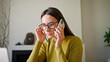 © VAKSMANV - Zooming in on busy Caucasian manager in glasses using laptop while calling to someone through phone. Hardworking businesswoman discussing about working task with her employees on cell phone.