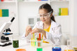 © New Africa - Little girl doing chemical experiment at desk indoors