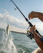 © Natalia - A man catches a fish while fishing from a boat. The fish is splashing in the water. The scene is set on a sunny day with a clear sky.