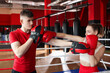 © New Africa - Woman in protective gloves having boxing practice with her coach at training center
