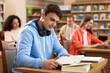 © New Africa - People studying at desks in public library, selective focus