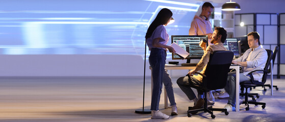 Wall Mural - male programmer with coffee cup and his team working in office at night