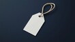 © risol - Blank white price tag with beige string loop on dark navy background