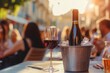 © SKIMP Art - A bottle of red wine is placed on an ice bucket at the dining table, with people eating and drinking in blurred focus behind it Generative AI
