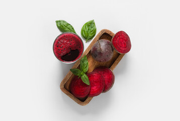 Wall Mural - Glass of fresh beet juice with basil and vegetables on grey background