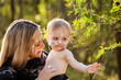 © Austockphoto - Portrait of Aboriginal mum holding baby boy faces painted in ochre in Australian bushland