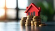 © RUENGWILAI - House Model on Stack of Coins Representing Real Estate Investment Property Finance and Wealth Growth