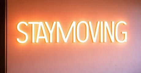 Poster - Bright neon sign displays STAYMOVING against warm orange wall. Simple typography creates motivational message. Minimalist aesthetic.