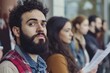 © Serhii - Confident Hipster Man Introducing Himself at a Forum with Registration List and Attendees in Line