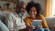 © Nathan - A joyful African American couple sharing a moment while using a tablet at home, radiating warmth and connection.