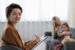 © New Africa - Mother and daughter having consultation with smiling psychologist in office, selective focus