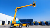 Articulated boom lift. Aerial platform lift. Telescopic boom lift against blue sky. Mobile crane parked at parking area for rent. Hydraulic boom lift at parking lot of crane dealership sale office.