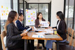 © SOMKID - Group of Asian business working plan analysis project brainstorm in modern office, Asian businesspeople team working together, Business startup and company strategy planning concept.