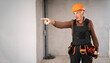 © Andrii Lysenko - Elderly mature male builder in safety helmet angry finger pointing at away with negative emotions. profession, construction and building concept.