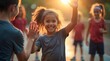 © Petro - A joyful young girl with curly hair celebrates during a playful game at sunset, surrounded by friends in athletic attire.
