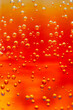 © faveteart - Bright orange liquid filled with fizzy bubbles captures the light